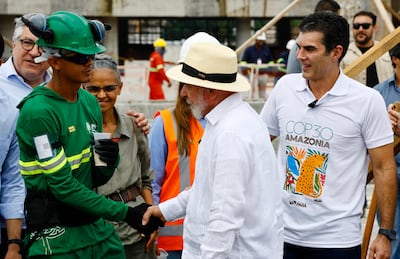 Brazilian President Luiz Inacio Lula da Silva, centre, and Para Governor Helder Barbalho, right, greet a worker during a visit to the area of Parque da Cidade, the venue that will host the activities of Cop30 in Belem, Brazil. AFP