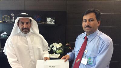 Taxi driver Noor Zad Khan receives his certificate of gratitude from Abdulaziz Al Jarwan, director of the Sharjah RTA. Courtesy RTA