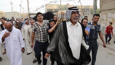 Friends and family members of victims in Sunday's suicide bombing grieve as they carry the coffins near the site of the attack during the funeral procession, in the Shula neighborhood of Baghdad, Iraq on October 12, 2014. Karim Kadim/AP Photo