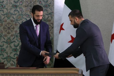 President Ahmad Al Shara receives Syria's constitutional declaration, which will be enforced through a five-year transitional period. AP