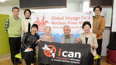 Three Japanese survivors of the atomic bomb (front 2nd L, 2nd R and R) pose with their supporters to congratulate ICAN on winning this year's Nobel Peace Prize. AFP PHOTO / JIJI PRESS / STR