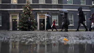 Visitors shield themselves from the rain outside 10 Downing St in London. The British Government continues to work out a deal on the matter of the Ireland border before Brexit negotiations with the EU can continue. Christopher Furlong/Getty Images