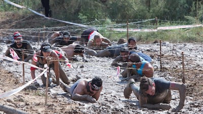 Competitors crawl under barbed wire during the Spartan Race in Hatta, Dubai. All photos by Leslie Pableo for The National