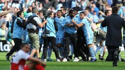 Manchester City's players and supporters celebrate on the pitch after their 3-2 victory over Queens Park Rangers in the English Premier League football match between Manchester City and Queens Park Rangers at The Etihad stadium in Manchester, north-west England on May 13, 2012. Manchester City won the game 3-2 to secure their first title since 1968. This is the first time that the Premier league title has been decided on goal-difference, Manchester City and Manchester United both finishing on 89 points. AFP PHOTO/PAUL ELLIS RESTRICTED TO EDITORIAL USE. No use with unauthorized audio, video, data, fixture lists, club/league logos or 'live' services. Online in-match use limited to 45 images, no video emulation. No use in betting, games or single club/league/player publications. *** Local Caption *** 507753-01-08.jpg