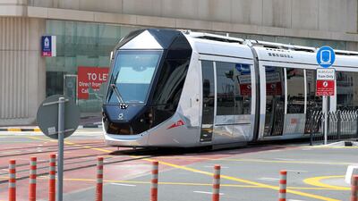 A tram trundles along the Marina's on-street rail tracks. Chris Whiteoak / The National