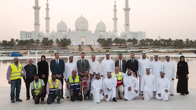 Sheikh Mohammed stands for a photograph with staff involved in the design and construction of Wahat Al Karama. Seen with Sheikh Khalifa bin Tahnoon (bottom row 6th R), and Mohammed Al Mubarak (bottom row 5th R). Ryan Carter / Crown Prince Court — Abu Dhabi