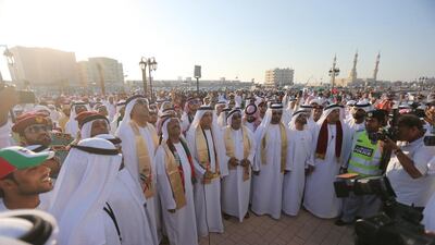 The Ruler of Ras Al Khaimah, Sheikh Saud (centre), arrives to unveil a large UAE flag as the nation celebrates its 42nd birthday. Sammy Dallal / The National