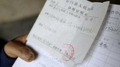 Gong Zhaoyuan, 69, shows a medical certificate from Shimen People’s Hospital which confirms he developed skin cancer as a result of arsenic poisoning, in Heshan village. Jason Lee / Reuters
