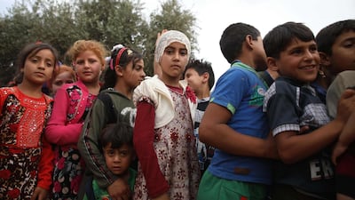 Syrian children queue up while waiting for toys to be distributed at a camp for Internally Displaced Persons in Idlib province. AFP