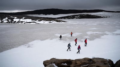 People walk on snow atop the Ok volcano crater on their way to a ceremony by the area which once was the Okjokull glacier, in Iceland. AP