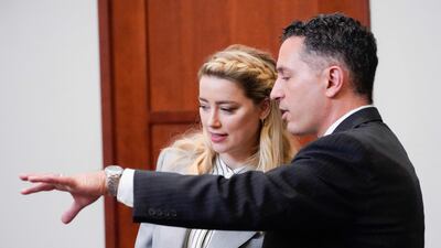 Heard speaks with her legal team. AFP