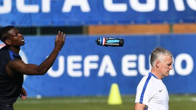 France midfielder Paul Pogba throws his water battle past France’s coach Didier Deschamps during a training session in the southern French city of Marseille on July 6, 2016 on the eve of their Euro 2016 Semi-Final match against Germany. Franck Fife / AFP