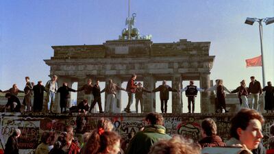 Berliners sing and dance on top of the Berlin Wall to celebrate the opening of East-West German borders in Berlin. Thousands of East German citizens moved into the West after East German authorities opened all border crossing points to the West. In the background is the Brandenburg Gate. AP Photo