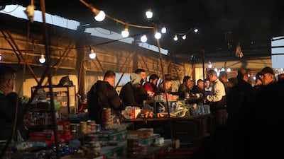 Palestinian workers buy food before crossing the Tayba check point to go to work in Israel on May 1. EPA