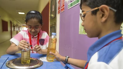 Pupils at Dubai’s Kindergarten Starters put cooking oil in a collection bin so it can be recycled in to biofuel. Antonie Robertson / The National