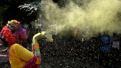 A girl is smeared with coloured powder during Holi celebrations, the Hindu spring festival of colours, in Kolkata on March 14, 2025. (Photo by DIBYANGSHU SARKAR / AFP)