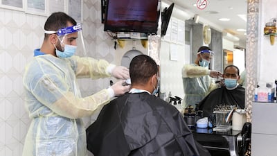 People get a hair cut in a barber shop following the easing of lockdown restrictions amid the Covid-19 pandemic, in Kuwait, Kuwait City. Kuwait on 18 August began the second phase of resumption to normal life which was disrupted due to coronavirus. EPA