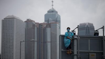 A protester keeps a look out from the top of a traffic signage pole. EPA