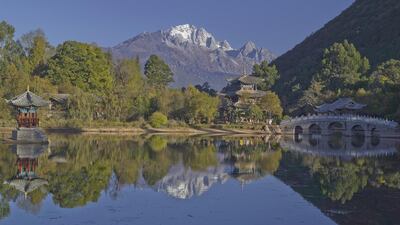 Black Dragon Lake in Lijiang’s old town, with a view of a pagoda and an arched bridge. The snow-capped Mount Yulong is also visible in the background. Courtesy Aman