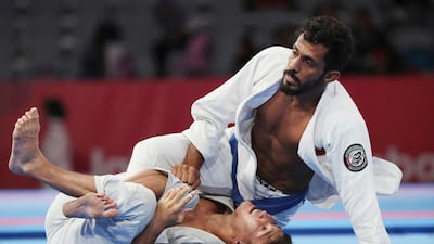 Talib Al Kirbi of the UAE, top, fights Kazakhstan's Nartay Kazhekov during the men's 69kg semi-final. Firdia Lisnawati / AP Photo