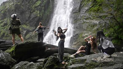 Visitors take pictures at Khlong Lan waterfall, in Thailand's Kamphaeng Phet province. AFP
