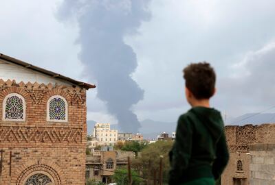 A boy looks at smoke rising in the distance after Israeli air strikes in Sanaa, Yemen. EPA