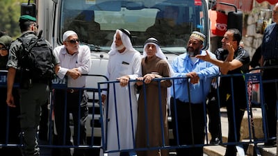 Palestinians stand next to a police barricade as they wait for the compound known to Muslims as Noble Sanctuary and to Jews as Temple Mount to be reopened, in Jerusalem's Old City July 16, 2017. REUTERS/Ammar Awad