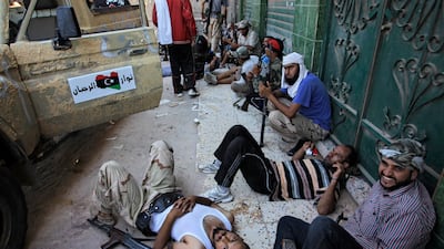 Rebel fighters rest in the shade in the village of Mayah, some 30 kilometers west from Tripoli, Libya, Sunday, Aug. 21, 2011. Libyan rebels said they were less than 20 miles (30 kilometers) from Moammar Gadhafi's main stronghold of Tripoli on Sunday, a day after opposition fighters launched their first attack on the capital itself. Fighters said a 600-strong rebel force that set out from Zawiya has reached the outskirts of the village of Jedaim and was coming under heavy fire from regime forces on the eastern side of the town. (AP Photo/Sergey Ponomarev) *** Local Caption *** Mideast Libya.JPEG-0cdfc.jpg