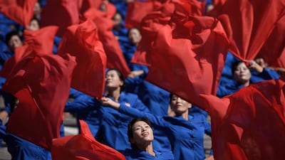 Participants wave flowers as they march past a balcony from where North Korea's leader Kim Jong Un was watching, during a mass rally on Kim Il Sung square in Pyongyang. AFP