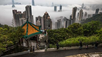People gather at the Peak viewpoint to watch fog over Hong Kong. AFP