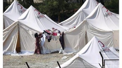 A woman hangs out clothes at a refugee camp in the border town of Yayladag in Turkey's Hatay province yesterday. The Turkish Red Crescent set up several camps in Yayladag when the first Syrian refugees arrived in April, and now plans to set up more. Osman Orsal / Reuters