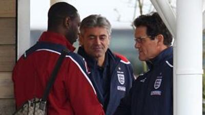 Ledley King, left, shakes hands with the England manager Fabio Capello, right, at Arsenal's London Colney training ground yesterday.
