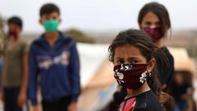 Children wear face masks sewed by displaced Syrian women at a camp for the internally displaced people near the town of Maaret Misrin in Syria's northwestern Idlib province. AFP