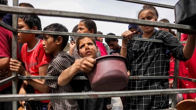 Children queue to receive charity meals from a kitchen in Beit Lahia, in northern Gaza. AFP