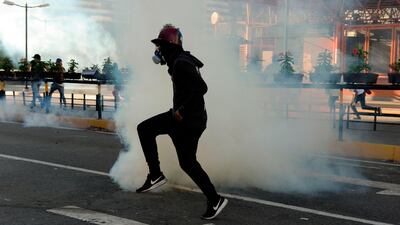 An opposition demonstrator wears a gas mask against tear gas during clashes with security forces. AFP