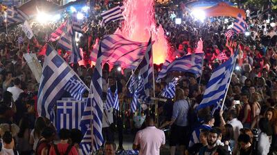 People celebrate in Athens after the first exit-polls of the Greek referendum. Louisa Gouliamaki / AFP