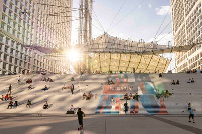 Visitors sit underneath the La Defense arch in Paris as the city prepares to host the Summer Olympics for the third time. Getty Images