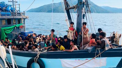 A wooden boat carries suspected Rohingya migrants detained in Malaysian territorial waters off the island of Langkawi, Malaysia. Malaysian Maritime Enforcement Agency via AP