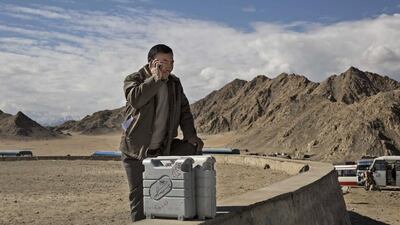 An election worker talks on the phone as he stands with voting machines while leaving a central collection point to head for a polling station.