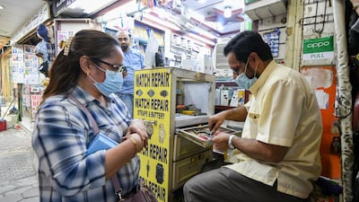 People wearing protective face masks walk in a street in Kuwait City, Kuwait. EPA