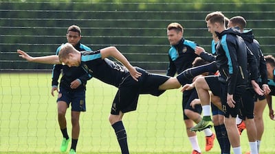 Arsenal's Per Mertesacker balances on one leg during a training session on Monday ahead of their Tuesday Champions League match. Andy Rain / EPA