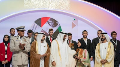 Sheikh Mohammed bin Zayed, Crown Prince of Abu Dhabi and Deputy Supreme Commander of the UAE Armed Forces, second right, and Sheikh Mohammed bin Rashid, Vice President and Ruler of Dubai, right, present an award to a winner, during the Sheikha Fatima bint Mubarak Awards for Excellence and Social Creativity, at Emirates Palace. They are seen with Ali bin Salem Al Kaabi, Director of the Office of the Minister of Presidential Affairs, and Chairman of the Board of Trustees of the Family Development Foundation, second left, and Major General Mohammed Khalfan Al Romaithi ,Commander in Chief of Abu Dhabi Police and Abu Dhabi Executive Council Member, left. Mohamed Al Hammadi / Crown Prince Court - Abu Dhabi