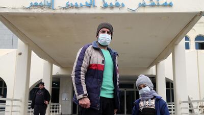 Visitors wearing protective face masks pose for a photograph after visiting Rafik Hariri University Hospital in Beirut, Lebanon. Bloomberg
