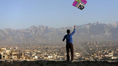 An boy flies a kite on a hilltop overlooking Kabul, Afghanistan, on February 17, 2014. Mohammad Ismail / Reuters