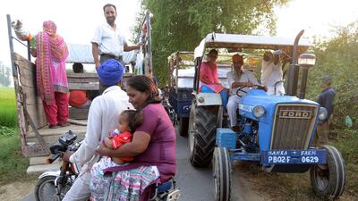 Indians ride on a tractor as they evacuate a village near Dauke, about 40 kilometres from Amritsar on September 29, 2016. The Punjab state government ordered an evacuation within a 10km radius from the India-Pakistan border. Indian commandos carried out strikes Friday along the border with Pakistan in Kashmir, provoking charges of “naked aggression” from its nuclear-armed neighbour. Narinder Nanu / Agence France-Presse