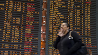 A traveller at the Charles de Gaulle international airport’s terminal 2 walks in front of a flight information board during a strike by air traffic controllers. EPA
