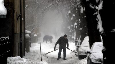 A Riga city worker clears snow from a sidewalk in Latvia. EPA