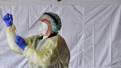A health worker examines a testing kit at a Corona testing station in Berlin. AFP