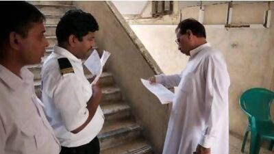 Security guards serve final eviction notices to tenants of Sheikh Rashid Colony.