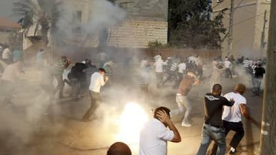 Israeli Arabs run for cover during clashes with Israeli police in Umm al Fahm yesterday.